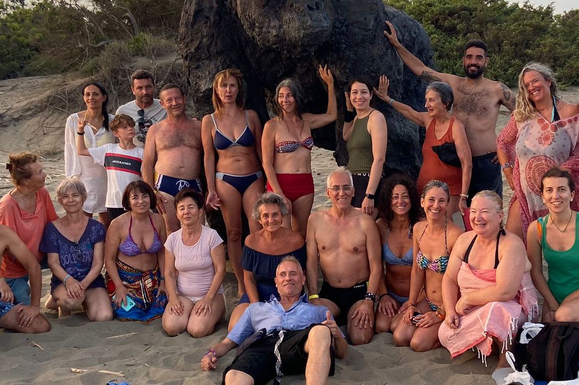 Foto di gruppo sorridente sulla spiaggia durante le vacanze olistiche di Tra Terra e Cielo a Riva dei Tarquini, estate 2024