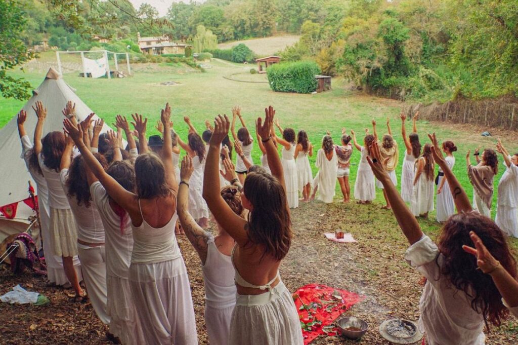 Donne in cerchio con le braccia alzate durante un rituale al Festival della Sacralità Femminile 2025