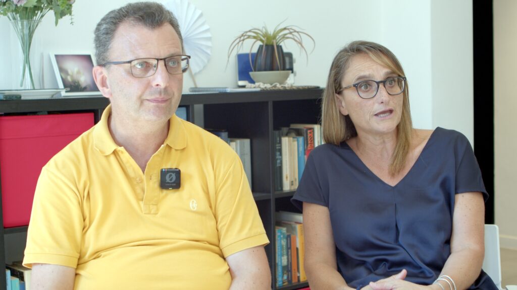 Due persone sedute in un ambiente.