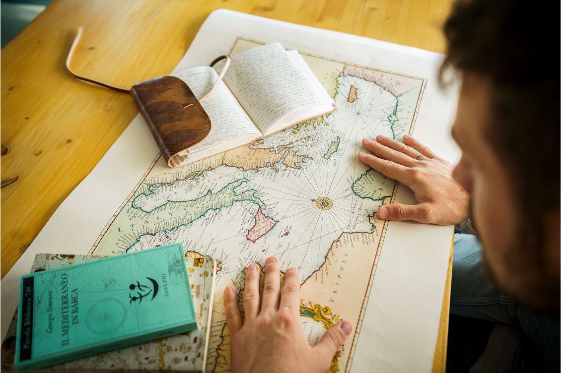 Mani su una mappa del Mediterraneo mentre si pianifica il viaggio Mediterrando