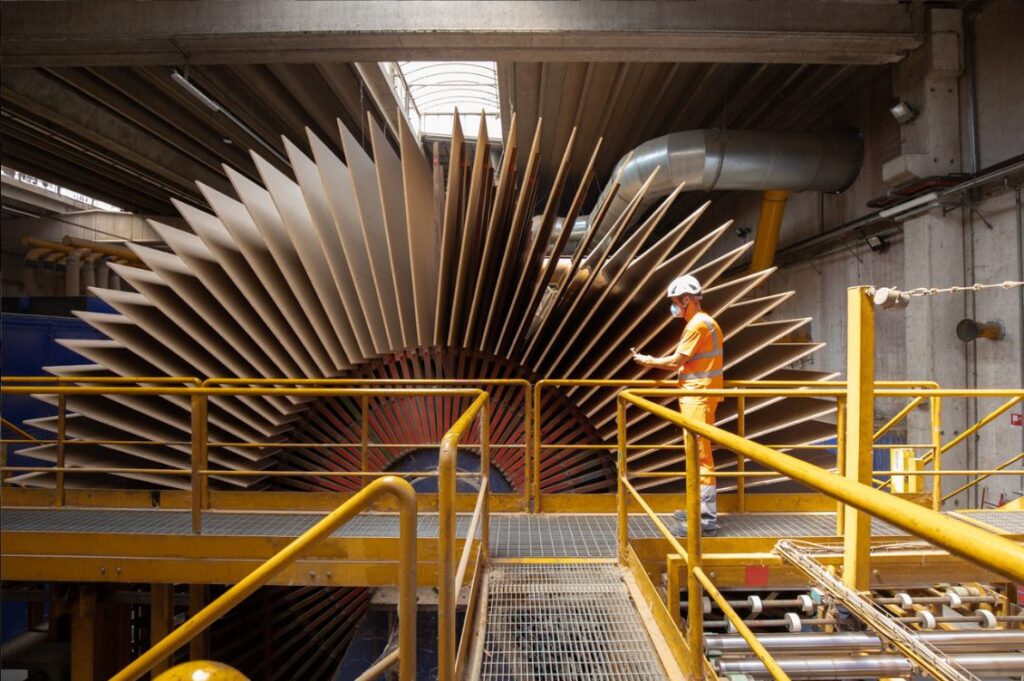 Fase di lavorazione industriale del legno post-consumo in uno stabilimento per la produzione di pannelli